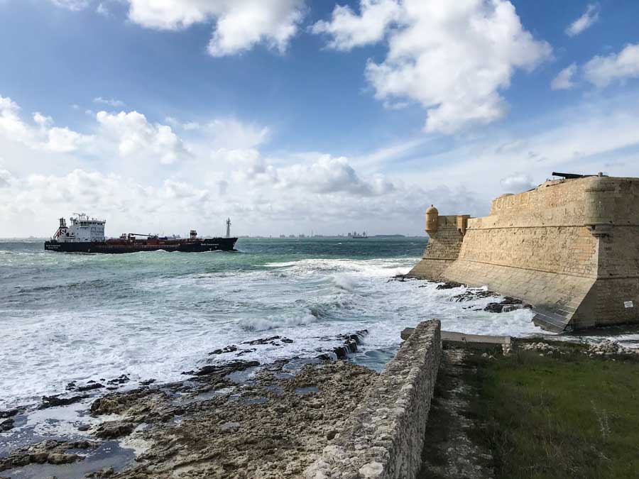 Ein Frachtschiff fährt in den Hafen von Port-de-Bouc ein und passiert dabei die Festung