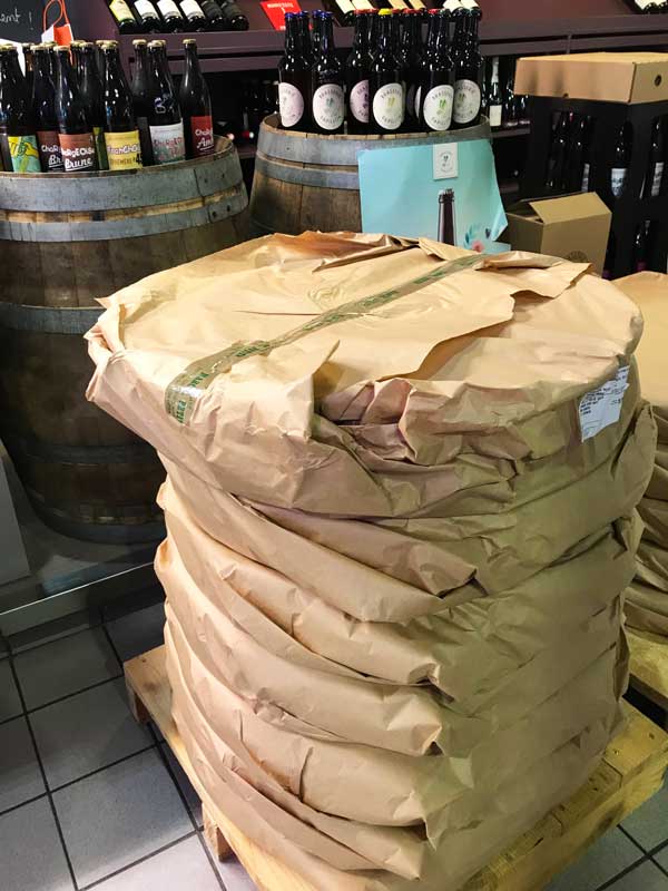 Käse- und Weinstand im Marché Couvert mit einem riesigen Stapel Comté
