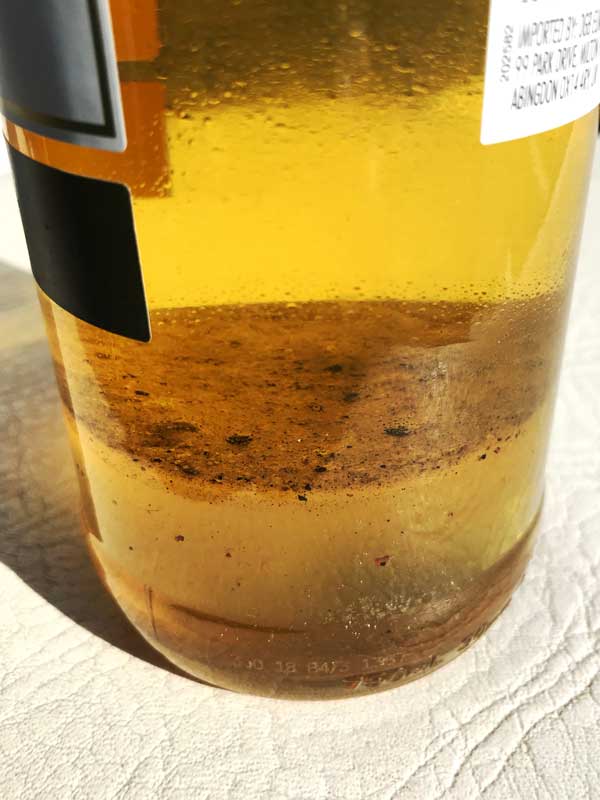 Als wir den alten Kraftstoff in Weinflaschen abfüllen, kann man sehr gut erkennen, wie die Flüssigkeit separiert