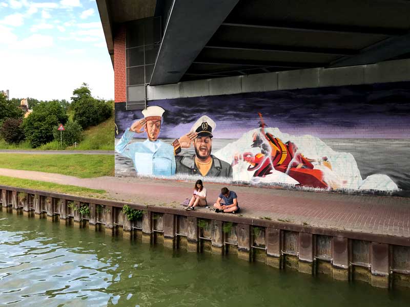 Schönes Graffiti mit Seemännern unter einer Brücke über den Dortmund-Ems-Kanal