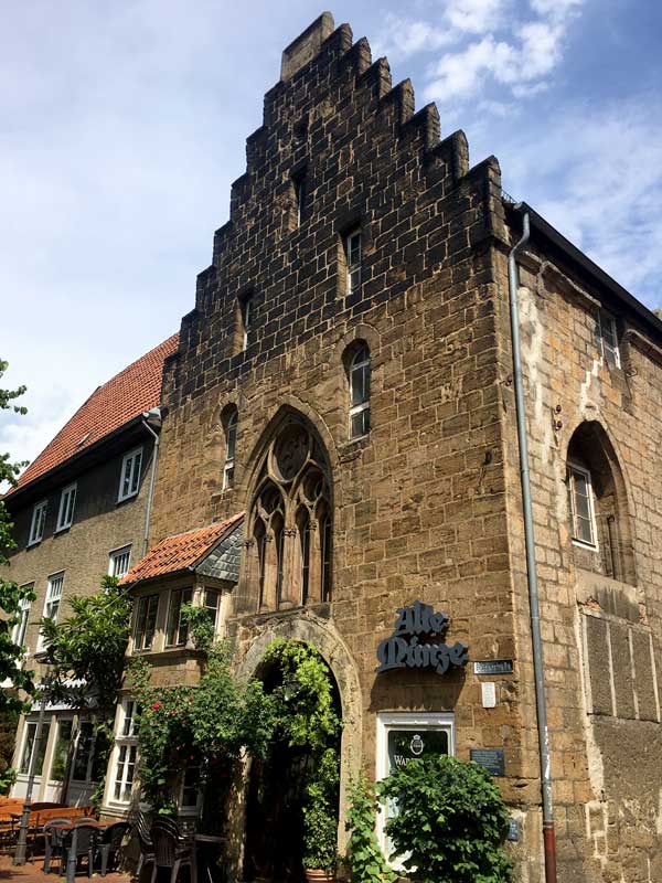 Die altes Münze in Minden ist ein Bau aus großen Steinquadern. Das Haus hat einen gestuften Giebel und Fenster, die an gotische Kirchenfenster erinnern