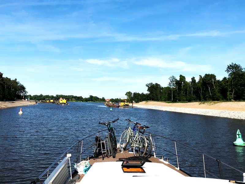 Die Fahrrine ist an dieser Stelle im Elbe-Havel-Kanal hinter der Schleuse Wusterwitz durch eine Baustelle stark verengt. Rote und grüne Tonnen begrenzen die Fahrrinne, rechts und links liege große Arbeitsplattformen im Kanal