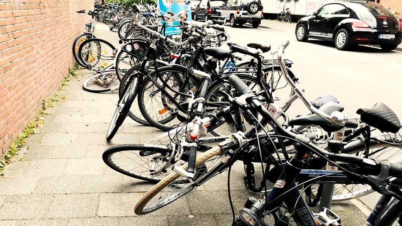 Fahrräder kreuz und quer auf dem ganzen Gehsteig