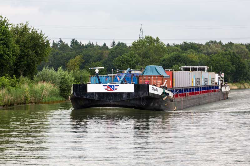Auf dem Mittellandkanal zwischen Minden und Hannover: Das Steuerhaus des Containerschiffs Charly ist soweit hochgefahren, dass der Kapitän über die Container drübergucken kann