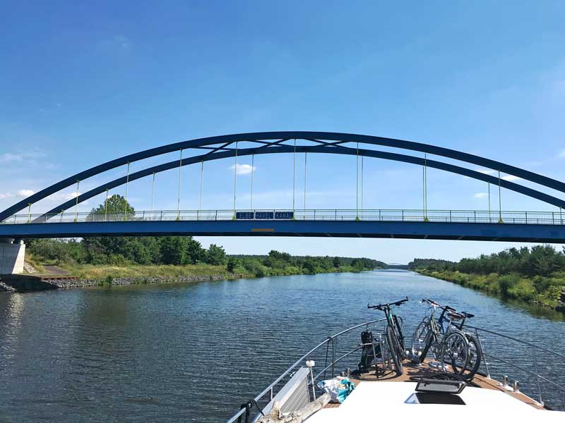 Über den Elbe-Havel-Kanal spannt sich eine blaue Brücke mit dem Schild "Elbe-Havel-Kanal"