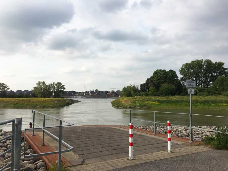 Im Vordergrund der Fähranleger und die Flutmulde, dahinter der Rhein und auf der anderen Flussseite die Stadt Rees