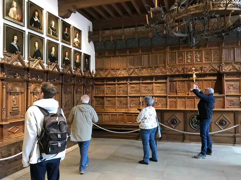 Der Friedenssaal im alten Rathaus von Münster ist gut besucht. An den Wänden hängen Portraits der Vertreter der Verhandlungsdelegationen