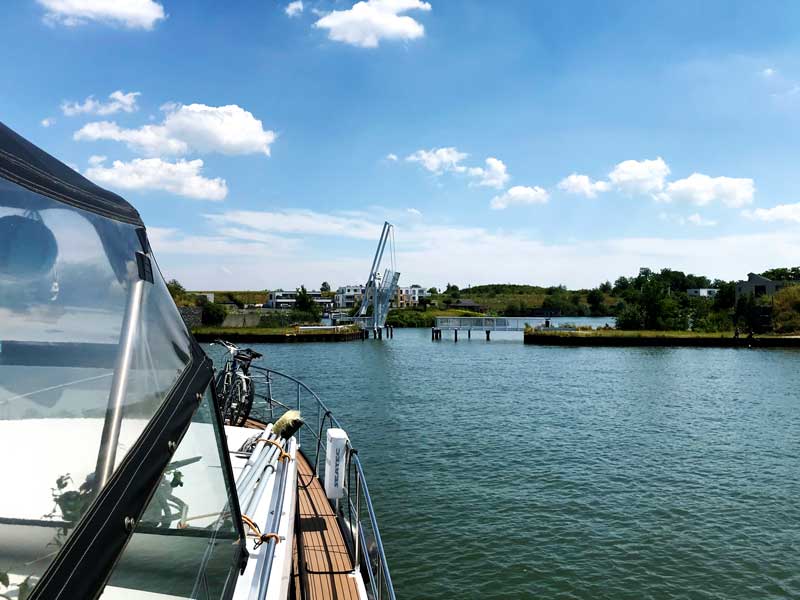 Vor uns hebt sich eine kleine weiße Hubbrücke, damit wir in die Marina Bortfeld einfahren können