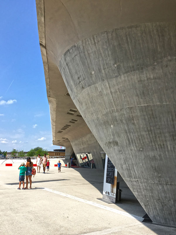 In der wunderschönen geschwungenen Flucht der Betonfassade des phæno Wolfsburg ist ein Aufsteller für ein Café so ungeschickt plaziert, dass er den Blick völlig zerstört