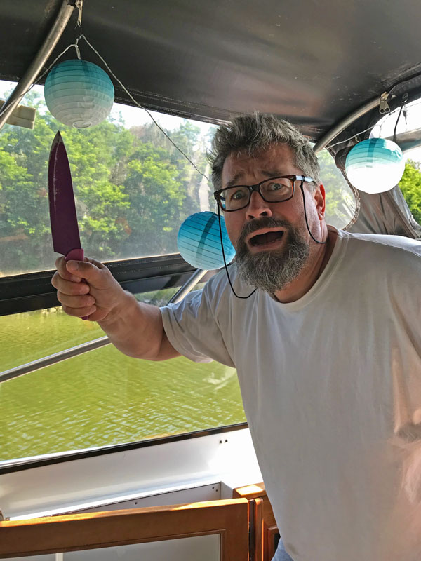 Thomas kommt mit dem panischem Gesichtsausdruck und erhobenem Messer aus der Kajüte gerannt