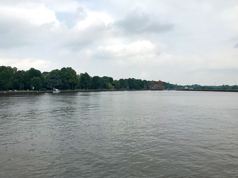 Blick vom Mittellandkanal zur Schleuse, die den Abstieg zur Weser ermöglicht. Es ist ein imposanter alter Ziegelbau mit mächtigen Türmen.