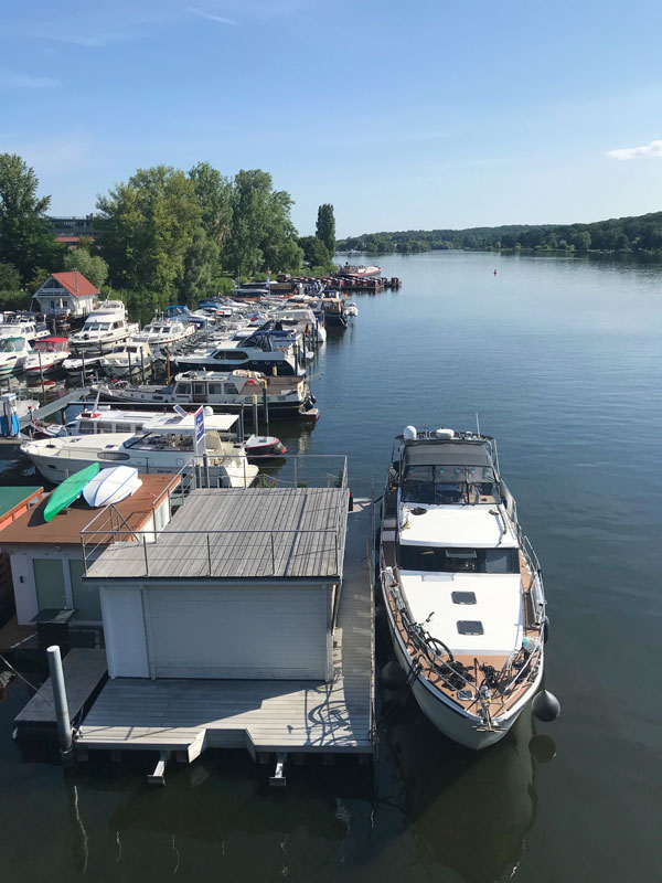 In der Marina am Tiefen See in Potsdam haben wir mit unserer Yacht außen an dem Schwimmfloss mit dem Gästezimmer der Marina angedockt. Blick über den Tiefen See Richtung Glienicker Brücker - links das Kulturquartier Schiffsbauergasse, gegenüber das Ufer von Babelsberg