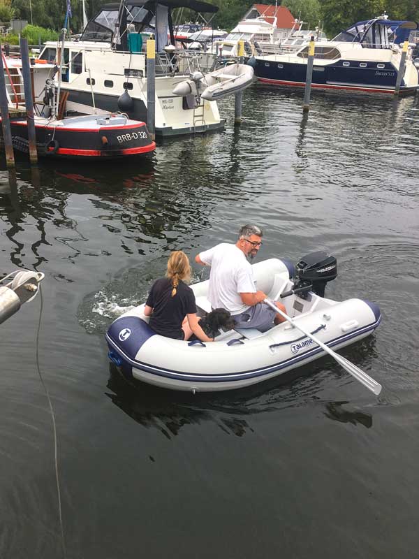 Thomas rudert im Hafenbecken der Marina am Tiefen See in Potsdam wieder zu unserer Yacht zurück. Mit an Bord sind der gerettete Hund und seine Betreuerin