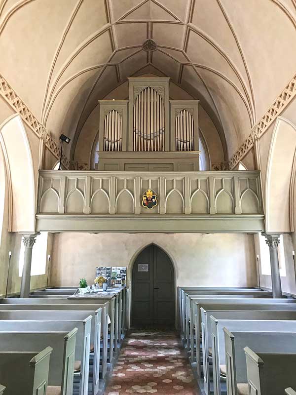 Das Innere der Dorfkirche von Paretz bei Ketzin Havel ist hell und in freundlichen Grün- und Blautönen gehalten. Hier Blick auf die Orgel über dem Eingang sowie Sitzbänke