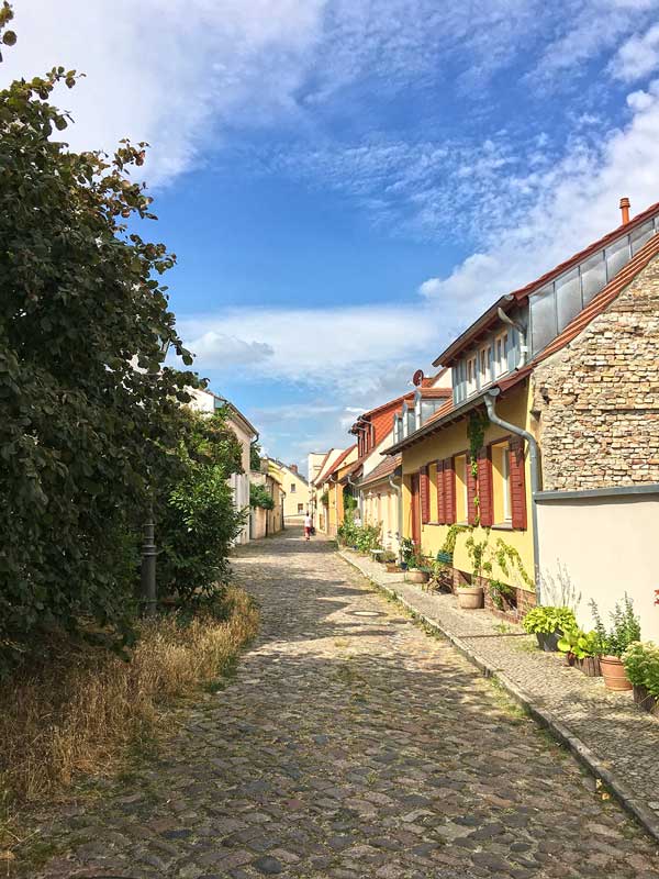 Dorfstraße in Werder Havel mit Kopfsteinpflaster und viel Grün