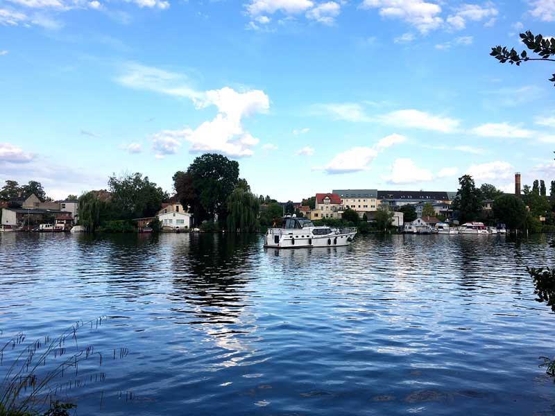 Das Boot liegt vor Anker auf dem Wasser der Bucht bei der Schlossinsel Köpenick bei Berlin