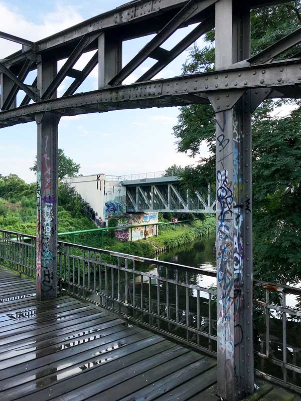Mariendorfer Hafensteg, eine Brücke über den Teltow-Kanal zwischen Berlin Steglitz und Mariendorf, mit Blick auf die Eisenbahnbrücke, alles mit Graffiti verziert