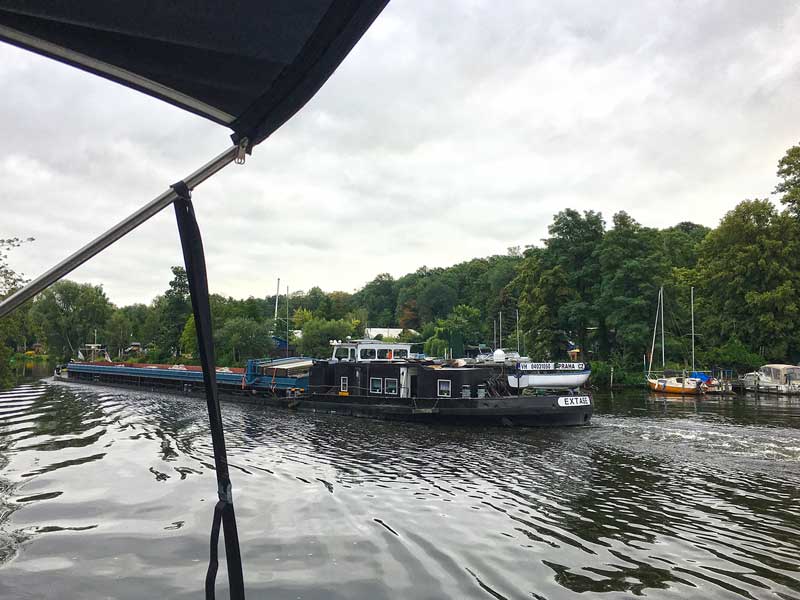 Ein älteres Frachtschiff fährt auf der schmalen Havel Richtung Spandauer Schleuse im Stadtteil Berlin Pichelsdorf