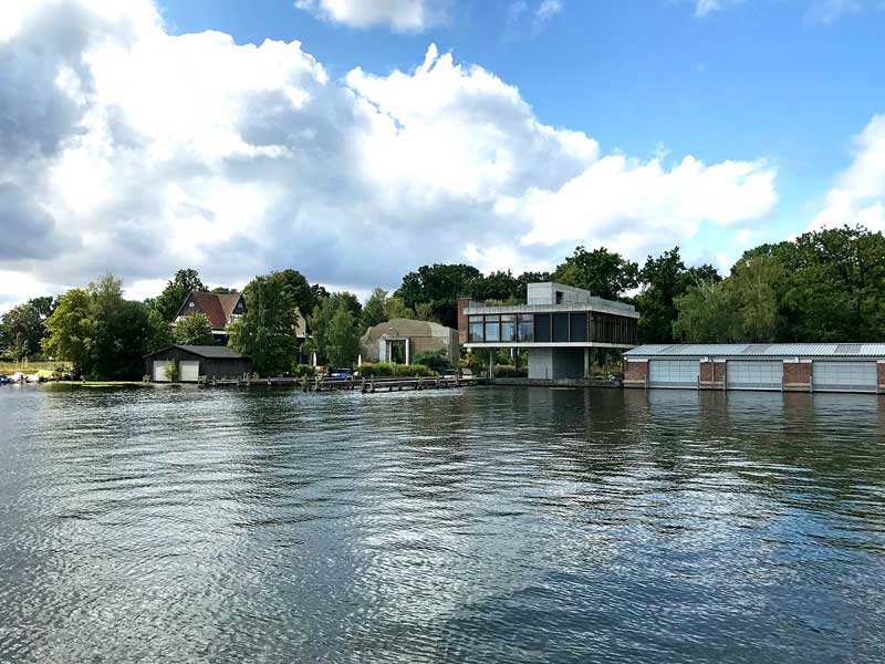 Modernes Wohnhaus aus Glas und Beton mit Bootshaus und Steganlagen am Ufer der Spree in Treptow