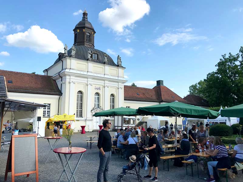Verpflegungsstation mit Tischen und Bänken und eine Bühne mit Musiker sind im Schlosshof in Köpenick bei Berlin aufgebaut