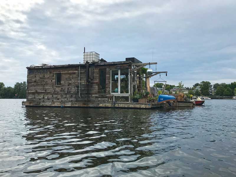 Ein romantisches Hausboot aus Holz ankert in der Rummelsburger Bucht auf der Spree in Berlin