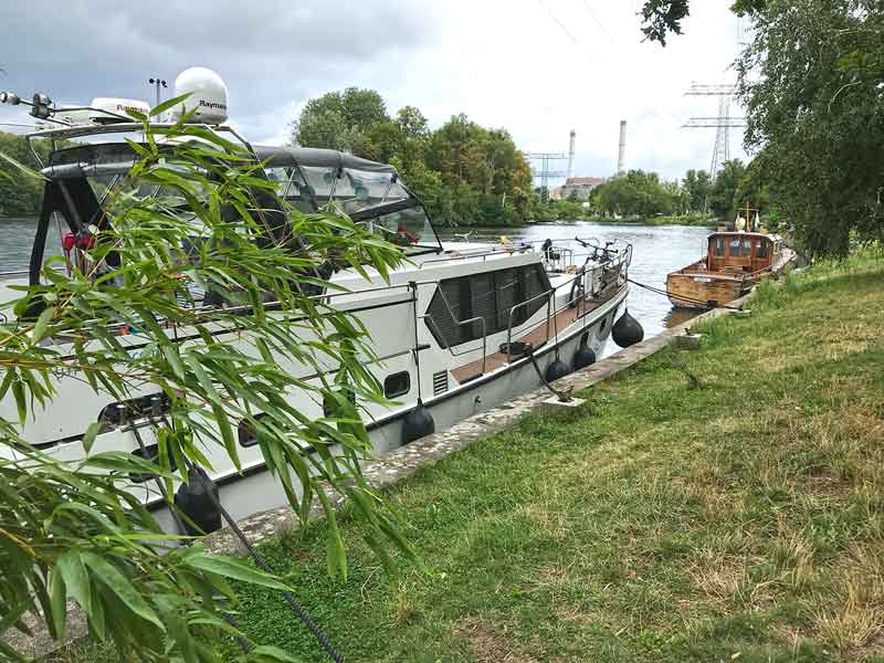 Das Boot liegt am grünen Ufer der Spree vor dem Funkhaus Berlin