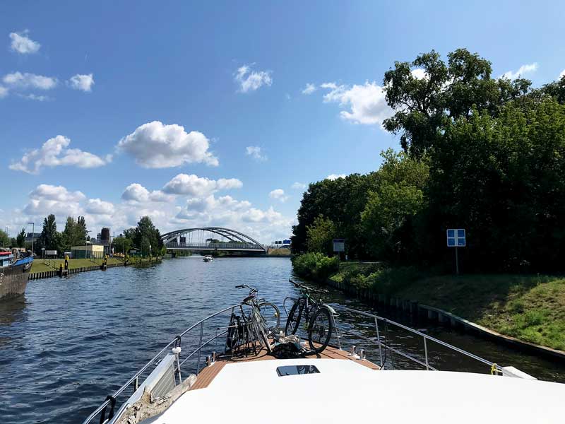 Das Schiff fährt auf eine Wasserstrassenkreuzung auf dem Teltowkanal in Berlin Neukölln zu