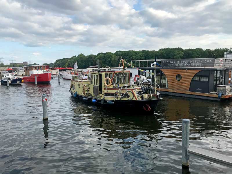 Ein hübsches altes Wohnboot fährt in den Hafen City Marina Berlin Rummelsburg an der Spree ein