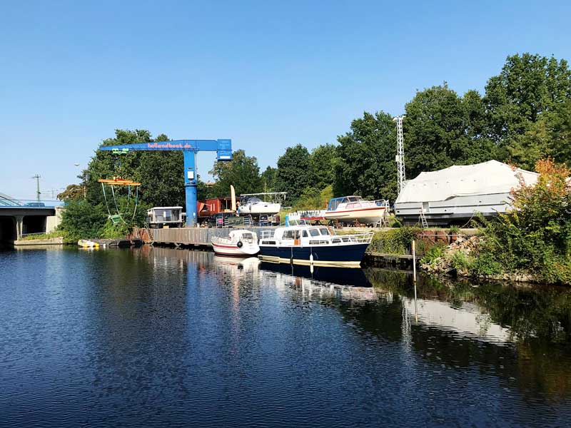 Kleine Werft mit Bootskran und Booten am Teltowkanal in Berlin