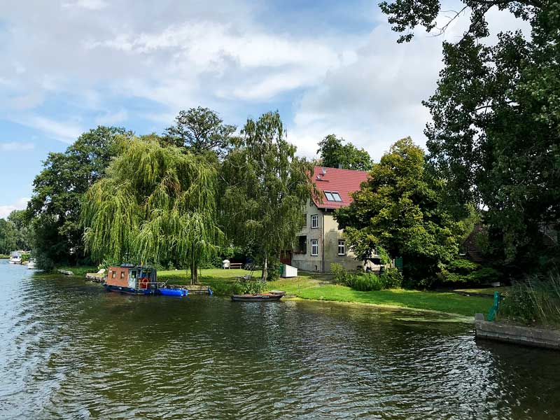 Entlang der Dahme bei Königs Wusterhausen, Brandenburg, südlich von Berlin, reichen schön gelegene Privatgrundstücke mit Trauerweiden und kleinen Bootsanlegern direkt bis ans Ufer
