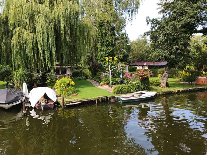Ufergrundstücke an der Dahme-Wasserstraße in Königs Wusterhausen, Brandenburg, südlich von Berlin. Kleine Häuser, sehr gepflegte Gärten, Trauerweiden, Bootsanleger.