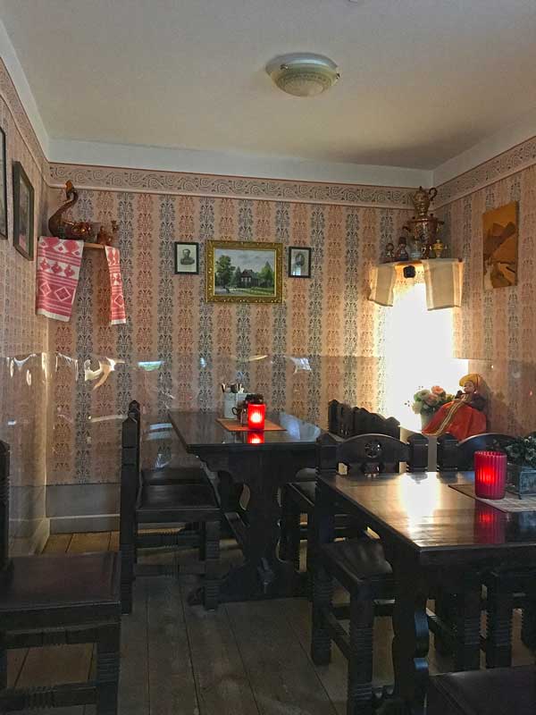 Gastraum im Restaurant, Teestube Haus 1 in der Russischen Kolonie in Potsdam, Brandenburg. Dunkle Holzmöbel, ornamentale Tapete, im unteren Bereich mit Plastik verkleidet