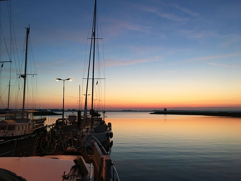Morgendämmerung an der Jachtensluis Volkerak, Blick über den Bug der Yacht