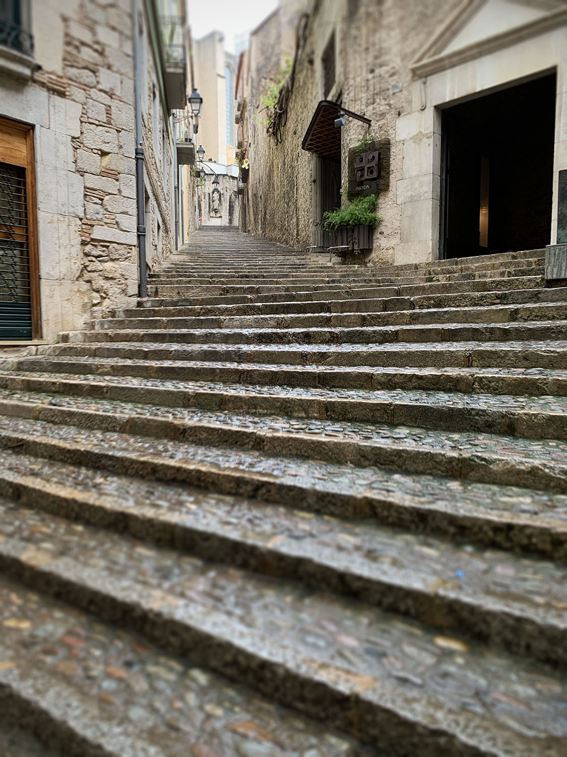 Eine Gasse im Barri Vel in Girona ist so steil, dass sie nur aus Stufen mit Kopfsteinpflaster besteht